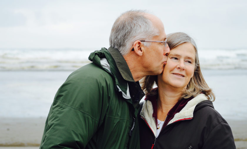 Older couple kissing on the beach